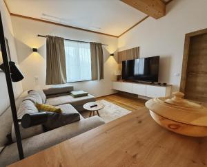 ein Wohnzimmer mit Couch und Flachbildfernseher in der Unterkunft Panoramablick Apartment Bad Aussee in Bad Aussee