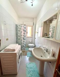 a white bathroom with a sink and a toilet at Nelly's house in Terrasini +27 photos