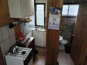 a small kitchen with a stove and a sink at Cabañas Edén Milenaria in El Cerrillo