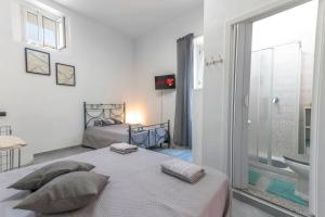 a white bedroom with a bed and a bathroom at EG House in Sarno