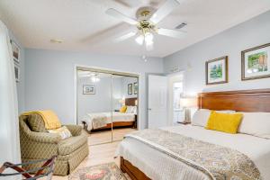 ein Schlafzimmer mit einem Bett, einem Stuhl und einem Spiegel in der Unterkunft Hilltop Golf Course Cottage in The Villages! in Lady Lake