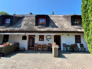 蒂豪尼Kékmadaras Vendégház Tihany的小屋设有茅草屋顶和庭院。