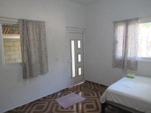 a bedroom with a bed and a window with curtains at surf la bamba in Dolores Miramar
