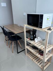 a microwave oven sitting on top of a wooden table at Hachi Flats - GRU in Guarulhos