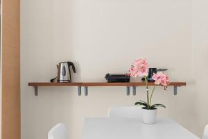 una mensola su una parete con un vaso di fiori di Beautiful Modern Beach Stay a Nikiana Altre 8 foto