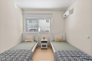 due letti in una piccola stanza con una finestra di Beautiful Modern Beach Stay a Nikiana