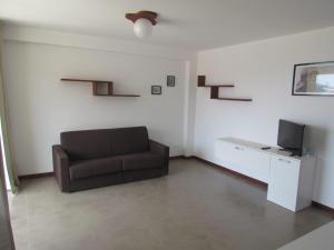 a living room with a couch and a tv at Apartamento T1 - Hotel Las Rochas in Mindelo