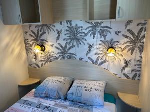 Una cama con dos almohadas encima en una habitación. en Chalet de jardin, piscine, en Seignosse