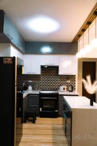 a kitchen with black cabinets and a white counter top at Gray Farmhouse in Buliwao