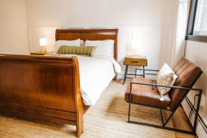 a bedroom with a bed and a cat sitting in a chair at SunStar Alaska Bed and Breakfast LLC in Anchorage