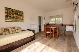 ein Schlafzimmer mit Bett und Tisch und eine Küche in der Unterkunft La Joaquina in Rosario de Lerma