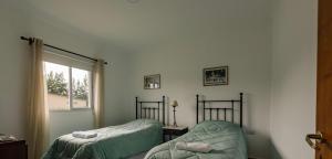 ein Schlafzimmer mit zwei Betten und einem Fenster in der Unterkunft La Joaquina in Rosario de Lerma