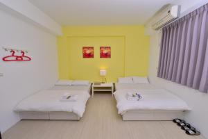 a room with two beds and a yellow wall at STSP Guest House in Xinshi