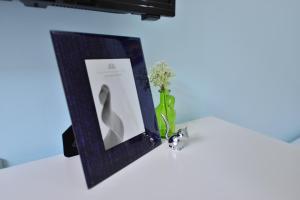 a picture frame and a vase with flowers on a table at STSP Guest House in Xinshi