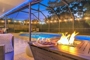 eine Terrasse mit einer Feuerstelle neben einem Pool in der Unterkunft Family Beach Home With Home Theater & Heated Pool! in Hollywood