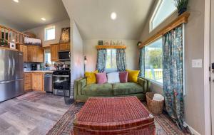 a living room with a green couch and a kitchen at Apple Blossom Bungalow in Sequim