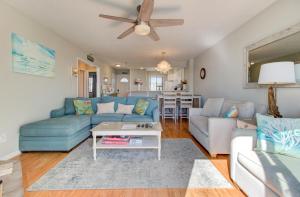 a living room with a blue couch and a table at Ocean Dunes 1504 by Carolina Beach Realty in Kure Beach