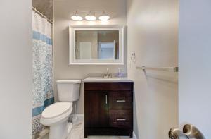 a bathroom with a toilet and a sink and a mirror at Ocean Dunes 1704 by Carolina Beach Realty in Kure Beach