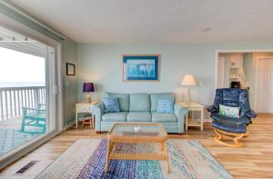 a living room with a couch and a chair at Ocean Dunes 2101A by Carolina Beach Realty in Kure Beach +39 photos
