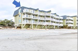 a large apartment building on the beach with an arrow at Ocean Dunes 2124C- Bella Vista by Carolina Beach Realty in Kure Beach