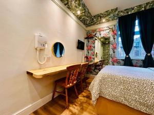 a bedroom with a bed and a vanity with a mirror at Rest Boutique Portobello in London