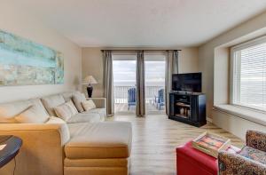 a living room with a couch and a tv at Ocean Dunes 2124C- Bella Vista by Carolina Beach Realty in Kure Beach
