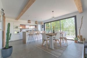 a kitchen and dining room with a table and chairs at Modern Villa Close to Beach in Tarnos