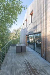 a wooden deck with a table on the side of a building at Modern Villa Close to Beach in Tarnos