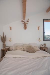 a bedroom with a bed with a deer head on the wall at Modern Villa Close to Beach in Tarnos +15 photos