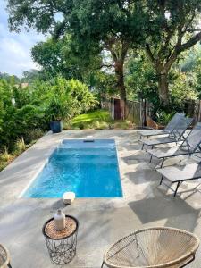 a swimming pool with chairs and a table at Modern Villa Close to Beach in Tarnos