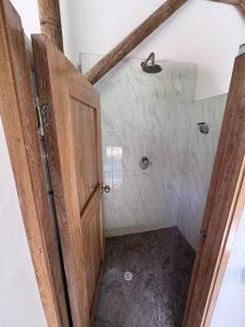 a bathroom with a shower with a wooden door at City Escape Casa Mariguana in Turbaco +21 photos