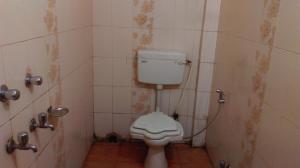 baño con aseo y pared de azulejos en Hotel Prince B en Guwahati