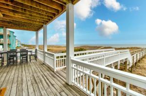 eine Veranda mit einem Tisch und Stühlen am Strand in der Unterkunft Ocean Oasis by Carolina Beach Realty in Carolina Beach