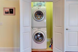 Waschmaschine und Trockner in einem Zimmer neben einer Tür in der Unterkunft Ocean Oasis by Carolina Beach Realty in Carolina Beach