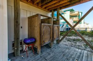 ein Holzhaus mit einem lila Hocker auf einer Terrasse in der Unterkunft Ocean Oasis by Carolina Beach Realty in Carolina Beach