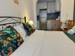 a bedroom with a bed and a kitchen at Green Parrot Apartments in Frátsia