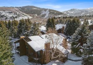 a house in the snow with mountains in the background at The Powder Haven Chalet in Park City