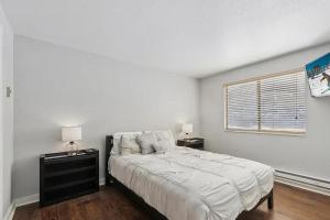 a white bedroom with a large bed and a window at The Powder Haven Chalet in Park City