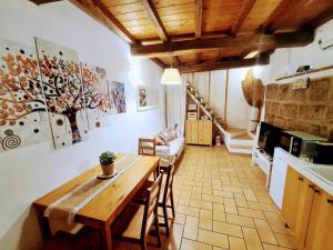 eine Küche und ein Esszimmer mit einem Holztisch und Stühlen in der Unterkunft Mad House Sutri Home Sweet Home Viterbo in Sutri