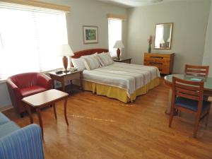 マイアミビーチにあるビスケイ ホテルのベッド、テーブル、椅子が備わるホテルルームです。