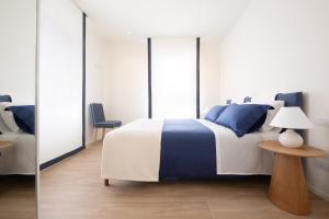 Schlafzimmer mit einem blauen und weißen Bett und einem Tisch in der Unterkunft Bellavista Holiday House in Valdobbiadene