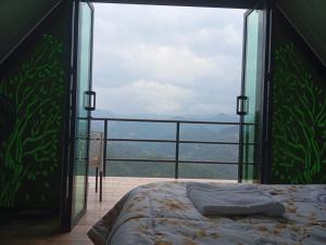 ein Schlafzimmer mit einem Bett und einem großen Glasfenster in der Unterkunft La Esmeralda in La Vega + 5 Fotos