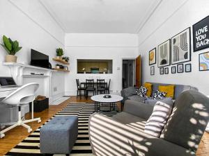 a living room with a couch and a table at Beautiful one bed garden flat in Muswell hill in London