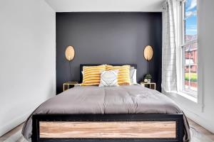 a bedroom with a large bed with yellow and white pillows at Urban Nest #1 Cozy studio near Proctor's & shops in Schenectady +5 photos