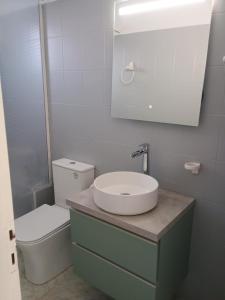 a white bathroom with a sink and a toilet at Seaside Serenity in Komi Beach! in Kómi +8 photos