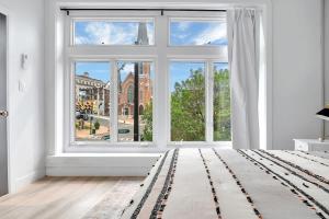 an empty white room with a large window at Urban Nest #3 Bright loft steps to Proctors in Schenectady