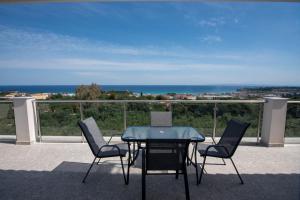 Una mesa y sillas en un balcón con vista al mar. en Gigi Star Luxury ApartVilla with Pool, Panoramic Sea View, en Tsilivi