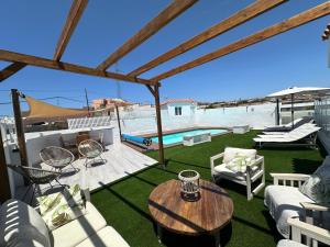 a patio with a table and chairs and a pool at Private pool, parking, BBQ in the South of GC in Las Palmas de Gran Canaria