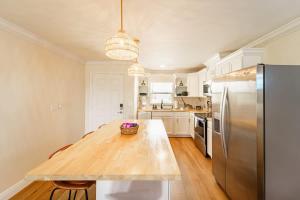 a kitchen with a wooden table and a stainless steel refrigerator at Sunset Suite Central to I75 airport & downtown in Punta Gorda