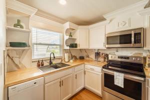 a kitchen with white cabinets and a stove top oven at Sunset Suite Central to I75 airport & downtown in Punta Gorda +69 photos